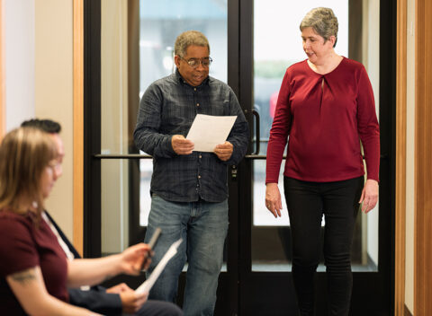 Gradient team member walking with client holding paperwork, showing approach to transportation compliance