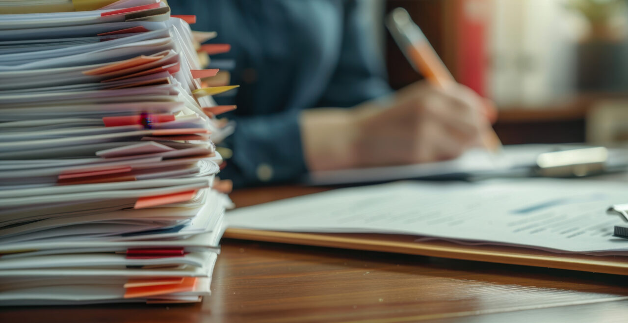 Stack of papers on a desk, showing how Gradient simplifies transportation compliance