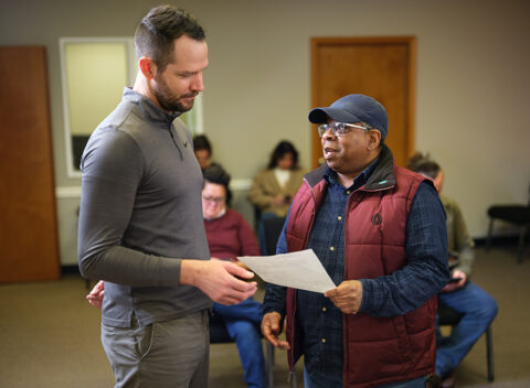 Gradient clinical team member going over paperwork with a client, showing physical examination compliance services