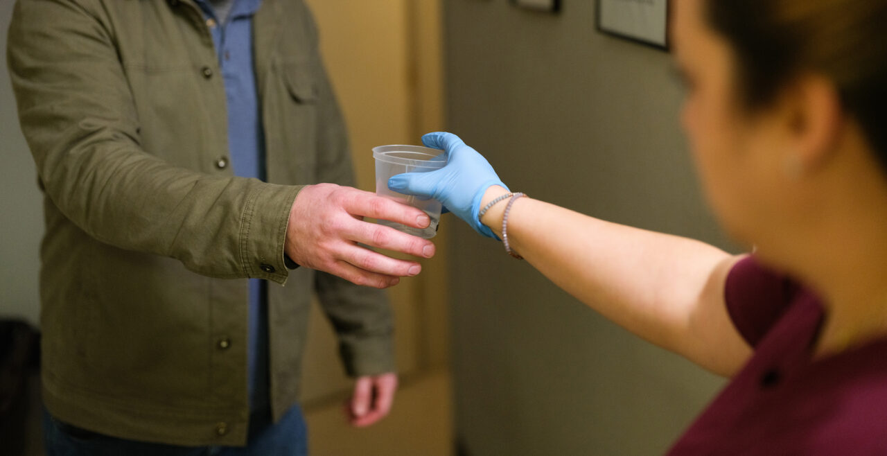 Gradient clinical team member handing a specimen collection for DOT compliance